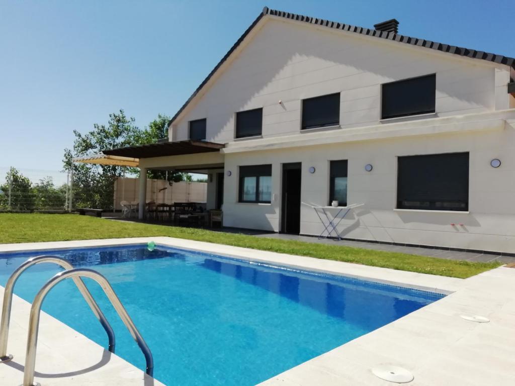 a villa with a swimming pool in front of a house at VillaTerreno Casa Rural en Logroño in Villamediana de Iregua