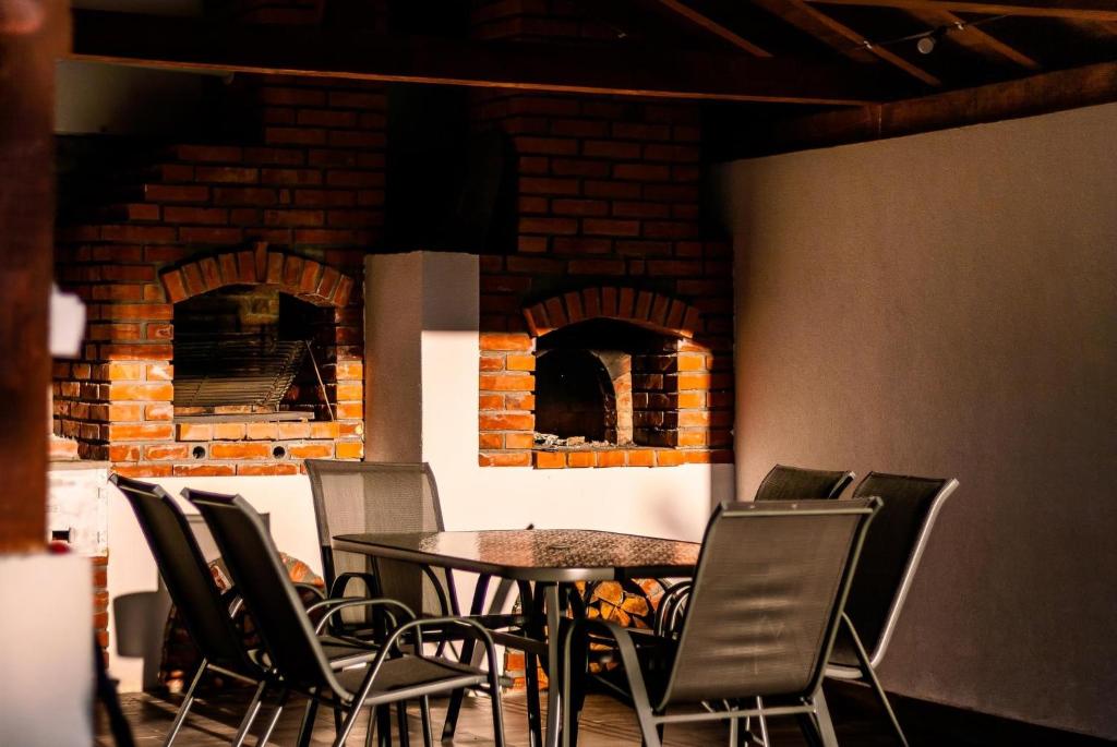 a dining room with a table and chairs and a brick oven at Vila Mishela in Berovo