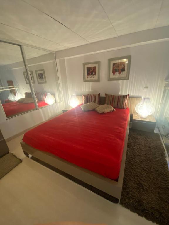 ニースにあるPROMENADE DES ANGLAISのベッドルーム1室(赤い大型ベッド1台、ランプ2つ付)