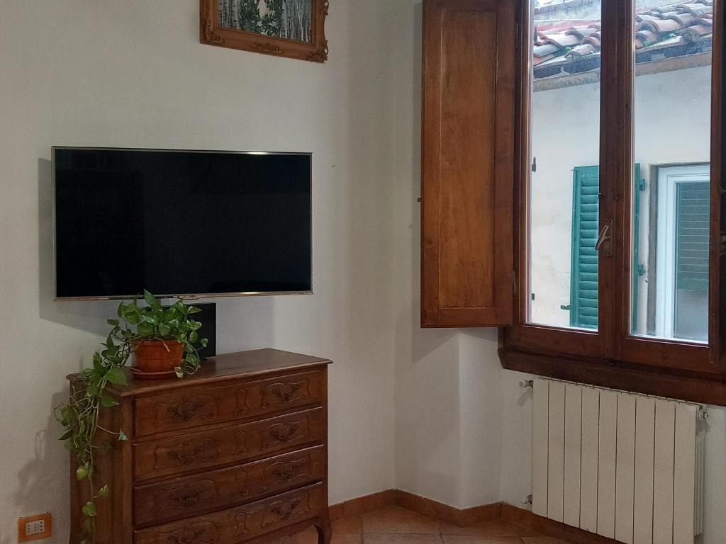 ein Wohnzimmer mit einem Flachbild-TV und einer Kommode in der Unterkunft Appartamento centro storico Firenze, Luna House in Florenz