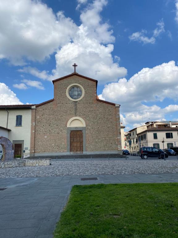 a church with a clock on the front of it at Berenice Housing in Prato