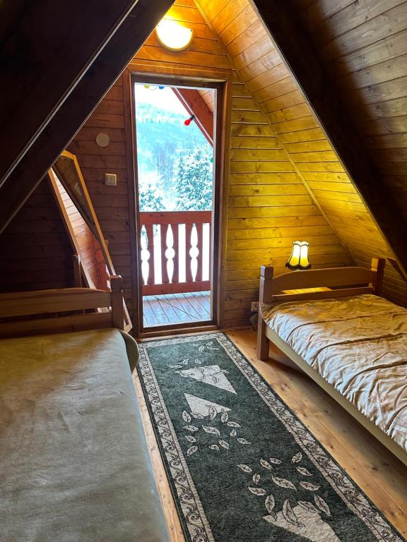 拉伊恰的住宿－Wichrowe Wzgórze 4，一间设有两张床的房间和一个位于小屋的窗户
