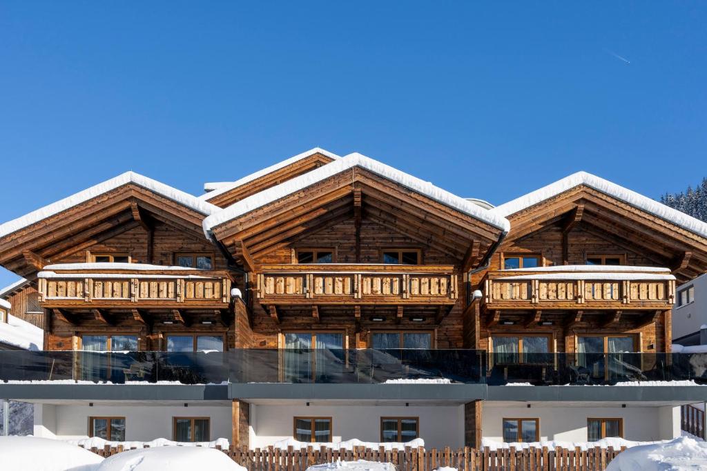 a log home with snow on the roof at Luf Lodges in Ischgl