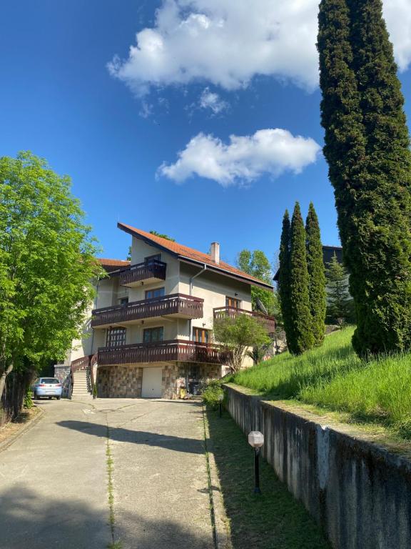 a house on a hill with a fence and trees at Vila Bellestay in Braşov