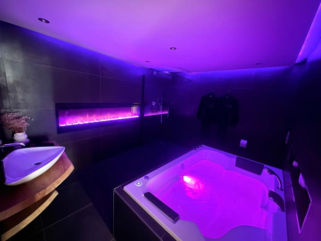 y baño con bañera con luz roja. en Maison Le Nid des Cigognes balnéothérapie pour 2, en Oberbronn