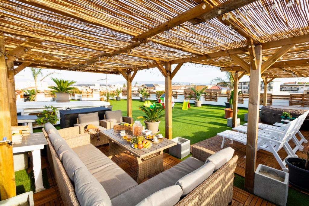an outdoor patio with a wooden pergola at Secret Paradise & SPA Rooftop in Quartu SantʼElena