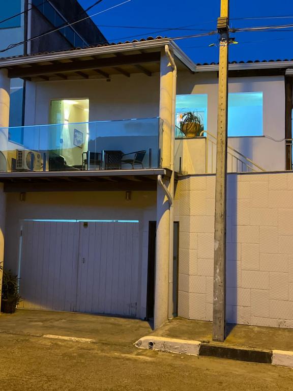 een huis met een garage en een balkon bij Casa Maury in Lauro de Freitas