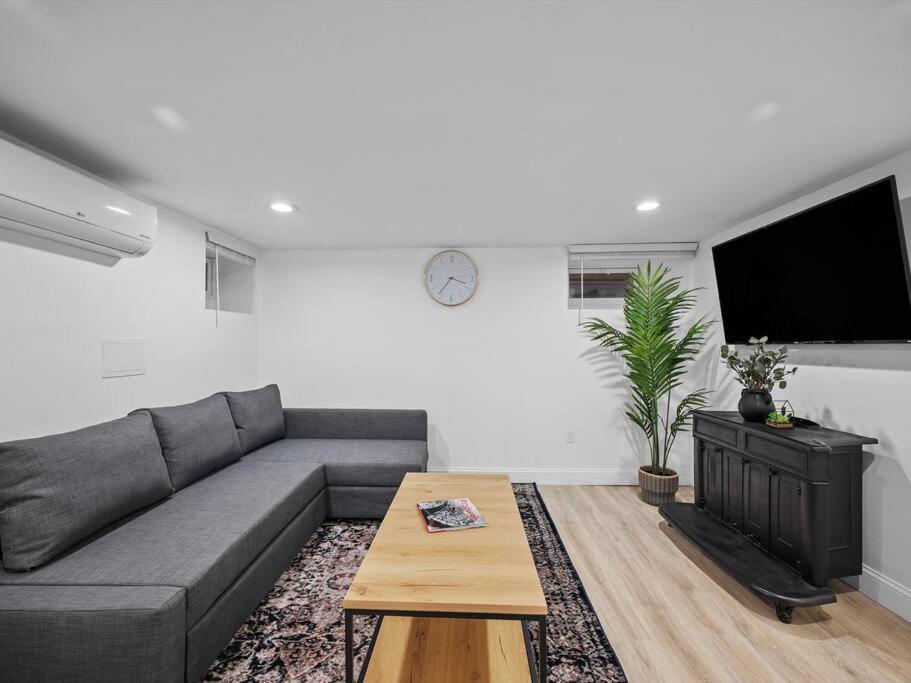 a living room with a gray couch and a table at Shadyside, Pittsburgh, Modern and Quiet 1 Bedroom Unit1 with Free Parking in Pittsburgh