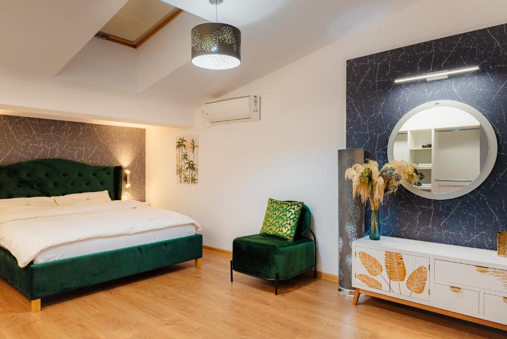 a bedroom with a bed and a mirror and a chair at Duplex lux - Thoria in Bucharest