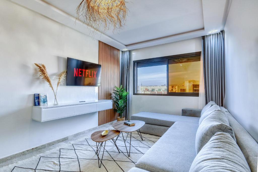 ein Wohnzimmer mit einem Sofa und einem Tisch in der Unterkunft Élégance - Appartement de luxe au centre d'Agadir in Agadir