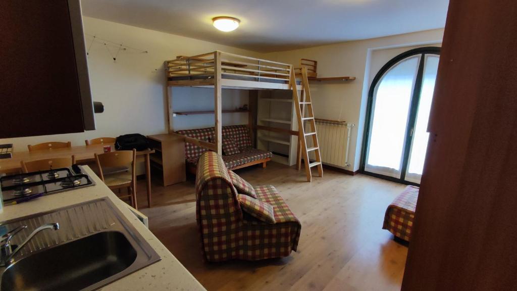 a living room with a bunk bed and two chairs at Casa Aprica piste da sci Baradello in Aprica