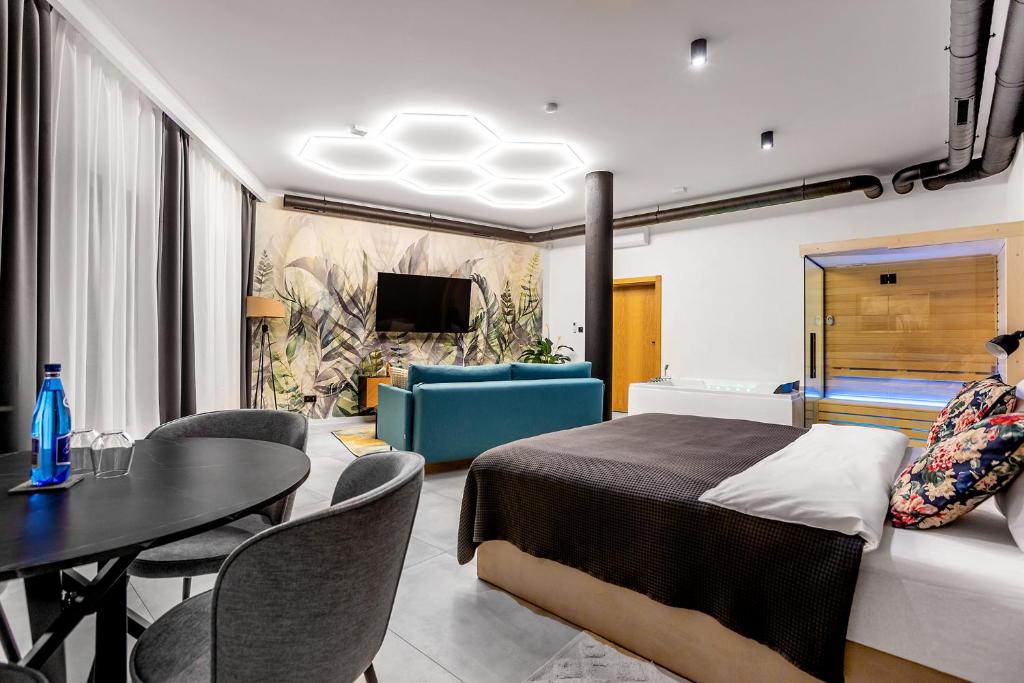 a bedroom with a bed and a dining room at Warowna 2 Premium Spa Jacuzzi & Sauna in Pszczyna