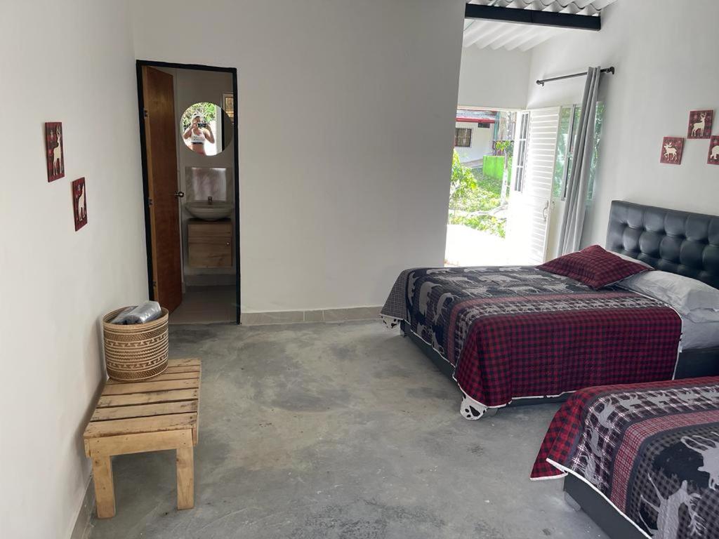 1 dormitorio con 2 camas, mesa y puerta en Blue River, en Santa Marta