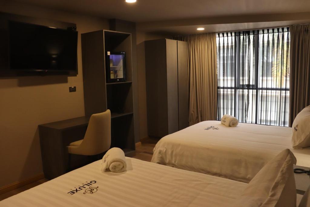 Postel nebo postele na pokoji v ubytování Giluxe Hotel