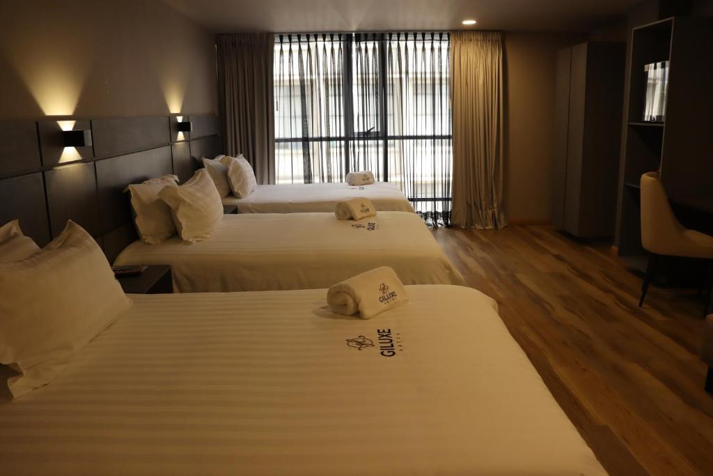 Postel nebo postele na pokoji v ubytování Giluxe Hotel