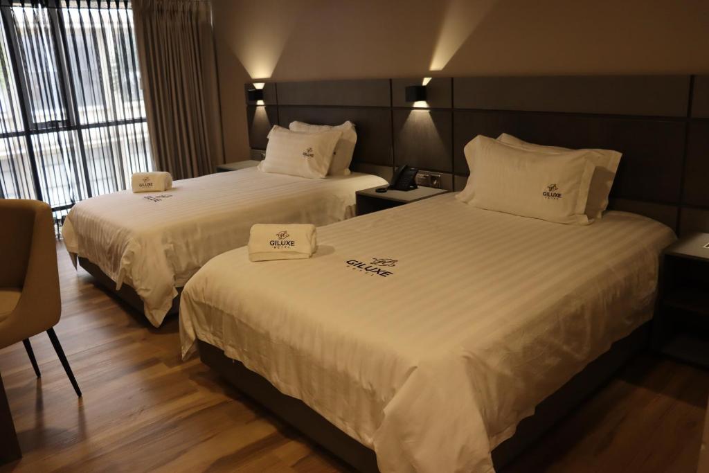 Postel nebo postele na pokoji v ubytování Giluxe Hotel
