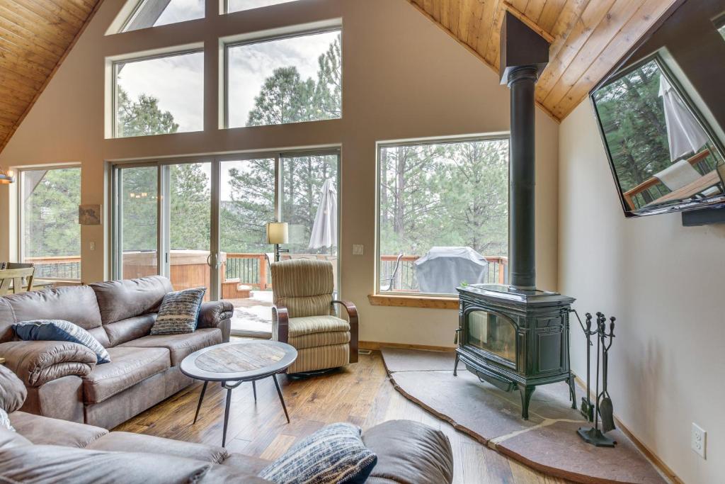 a living room with a couch and a stove at Angel Fire Cabin with Deck 3 Mi to Ski Lifts! in Angel Fire