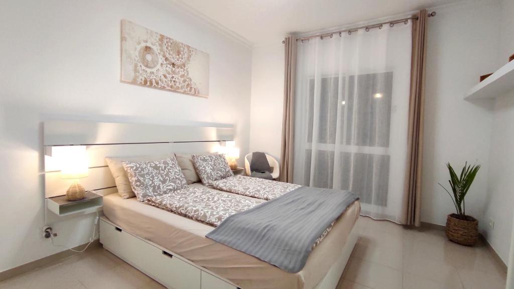 een slaapkamer met een groot bed en een raam bij Residential Golf Park - Casa Prezi in San Miguel de Abona