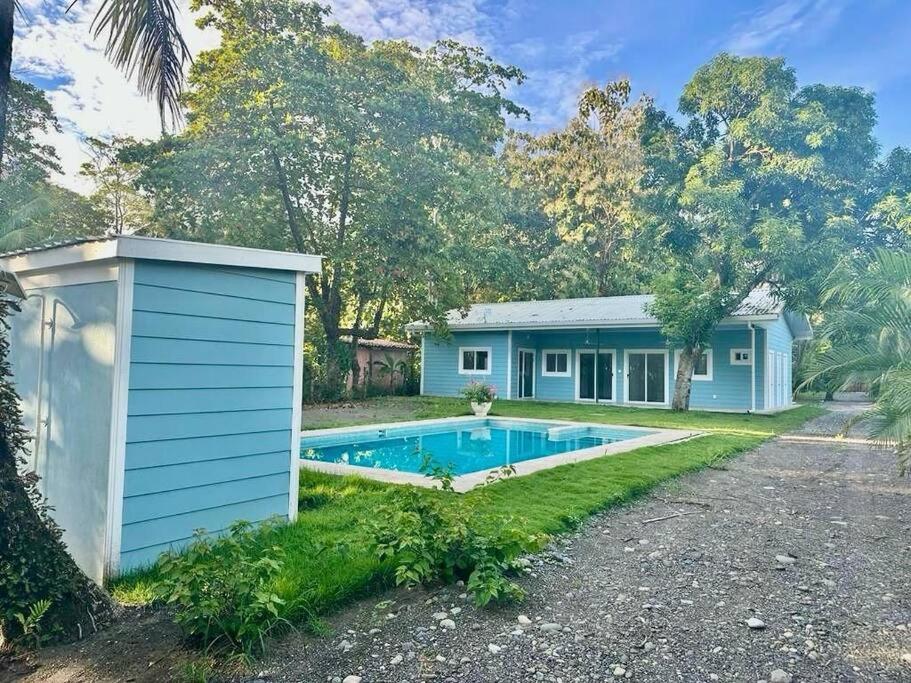 a blue house with a swimming pool in the yard at Villa Cielo, Casa de playa in Jacó