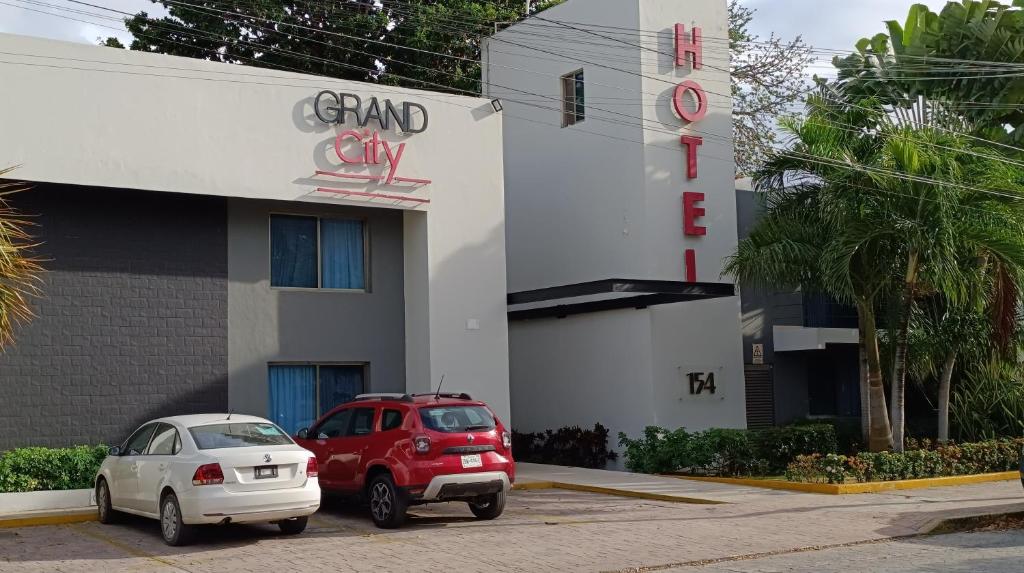 dos coches estacionados frente a un edificio en Grand City Hotel Cancun, en Cancún