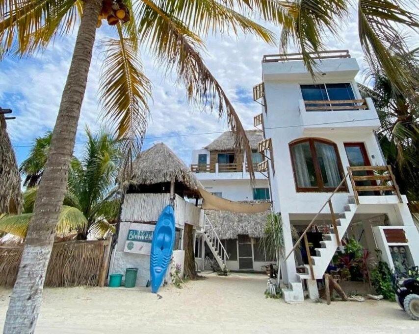 een huis op het strand met een blauwe surfplank bij Casa Tropicana in El Cuyo