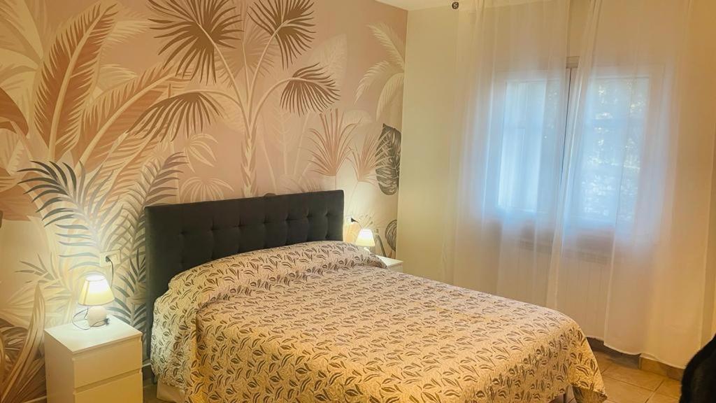 a bedroom with a bed and a wall with a plant mural at Appartamento Polpenazze in Polpenazze del Garda