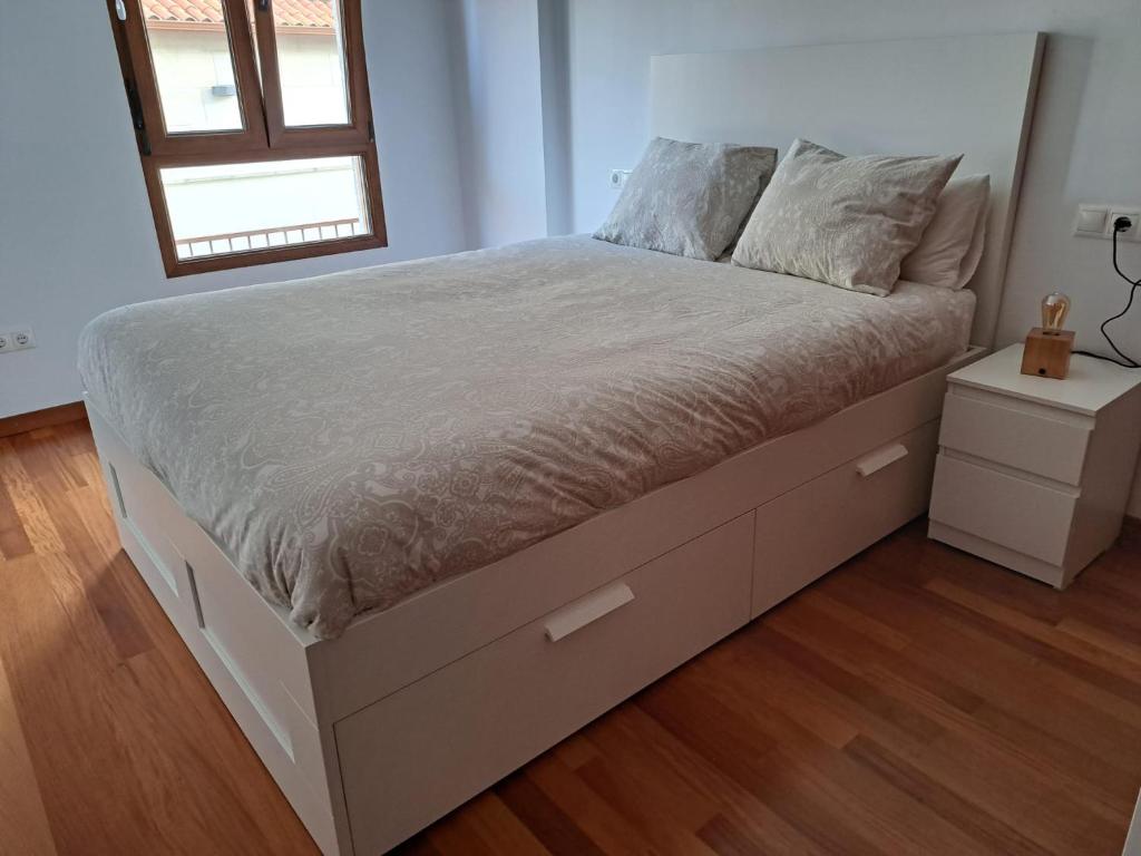Łóżko w sypialni z drewnianą podłogą w obiekcie Playa del prado w mieście Ribeira