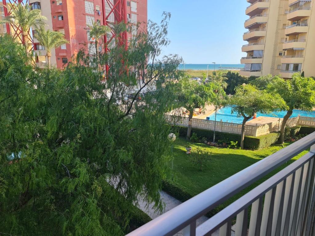 a balcony with a view of a swimming pool at Bonito apartamento con vistas al mar in Playa Pobla de Farnals
