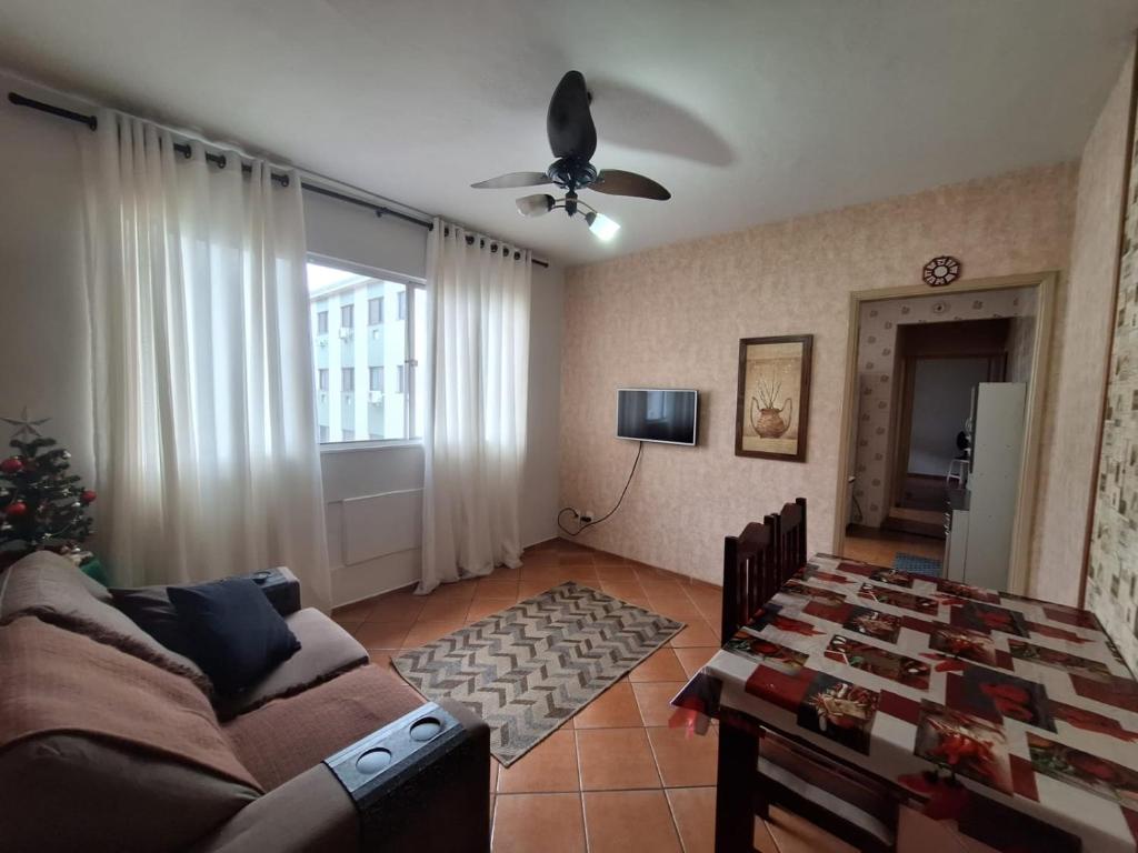 een woonkamer met een bank en een tafel bij Apartamento em São Vicente in São Vicente