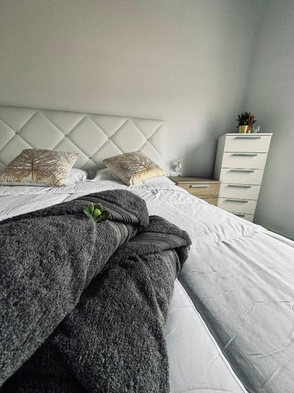 ein Schlafzimmer mit einem Bett mit grauen Decken und einer Kommode in der Unterkunft Avenida 52 B in Los Llanos de Aridane