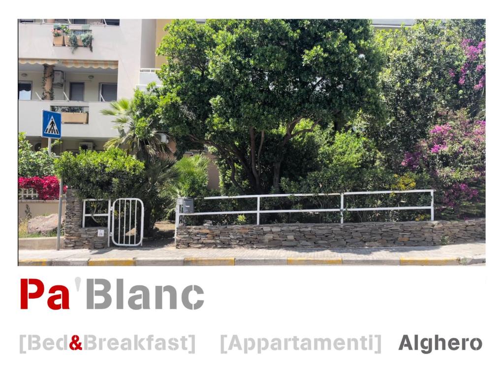 a park with a fence and a tree at Pà Blanc Apartments in Alghero