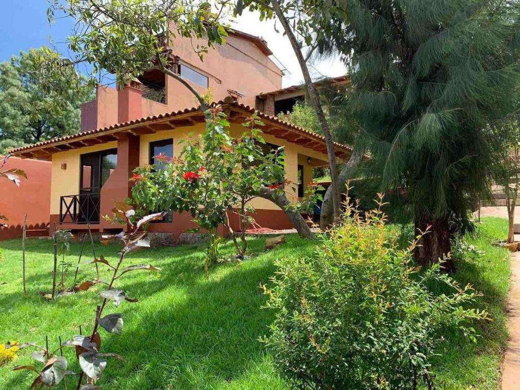 une maison avec un jardin en face dans l'établissement Brisas de Sol, à Pátzcuaro