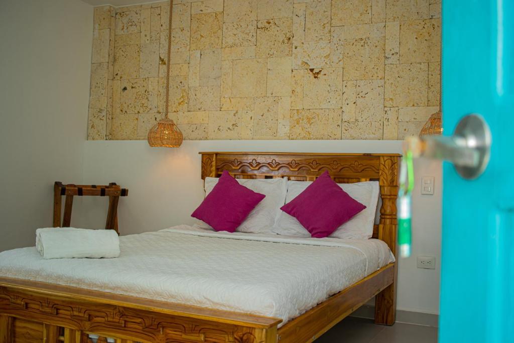 a bed with purple pillows in a room at Casa Playa James in Los Arrayanes