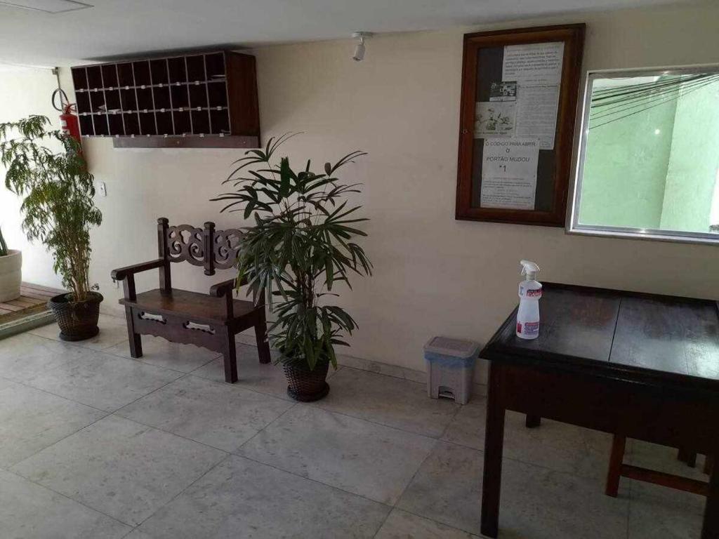 a room with a bench and a potted plant at Apartamento Saquarema Centro in Saquarema