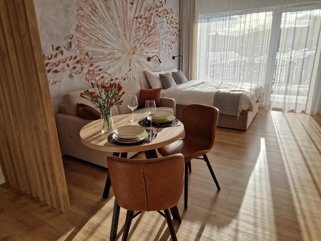 a room with a table and a bed and a bedroom at Apartament Sunray in Krakow
