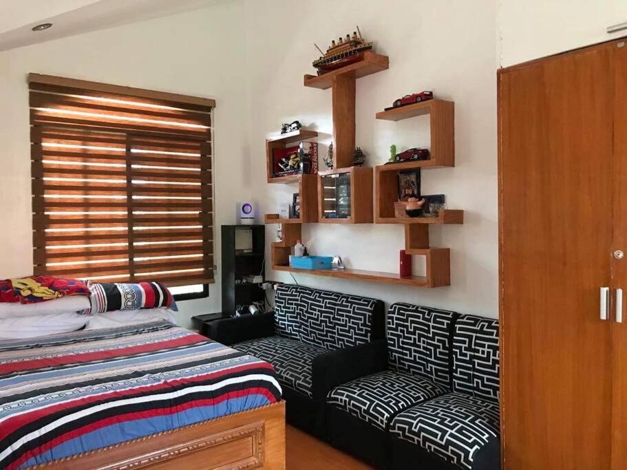 ein Schlafzimmer mit einem Bett, einem Sofa und einem Fenster in der Unterkunft House on the Hill in Carmona