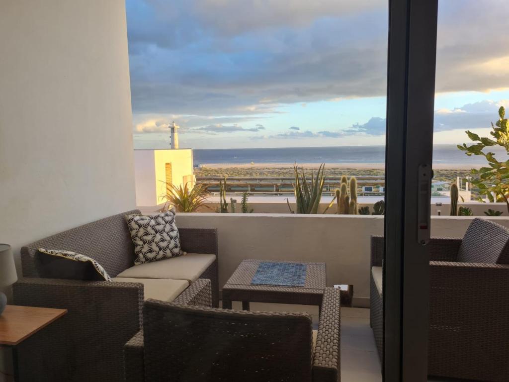 balcón con sofá y vistas al océano en Apartment Casa M in Morro Jable, en Morro del Jable