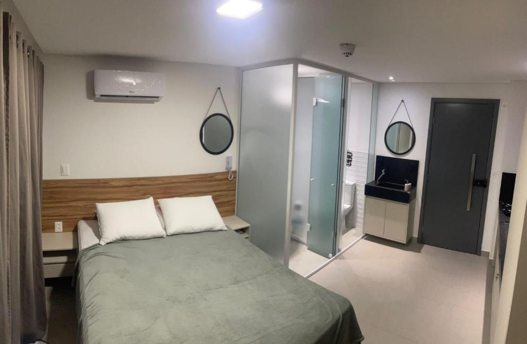 a bedroom with a bed and a glass wall at Flat João Pessoa Frente Mar - Banheira - Jacuzzi Privativa in João Pessoa