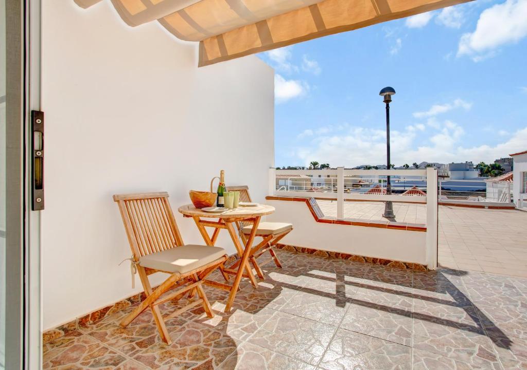 a patio with a table and chairs on a balcony at Silvic Serenada in Corralejo