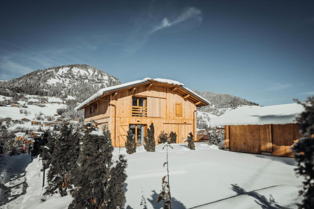 a log cabin in the snow with a fence at Nards furnished chalet in Praz-sur-Arly