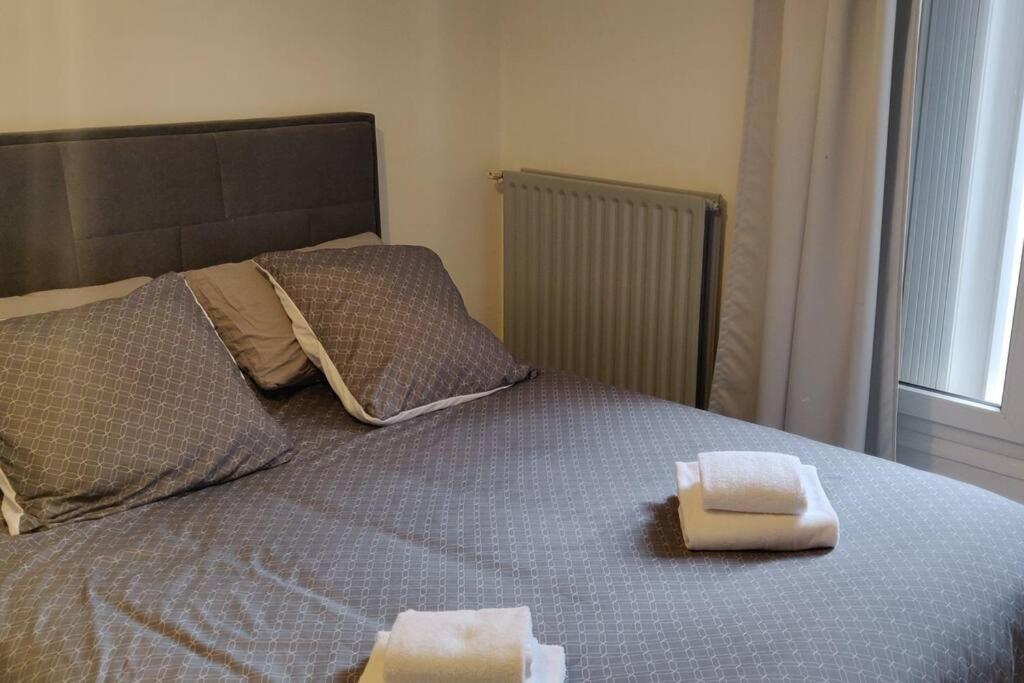 a bed with two towels sitting on top of it at Cosy Appartement Paris Ouest in Suresnes
