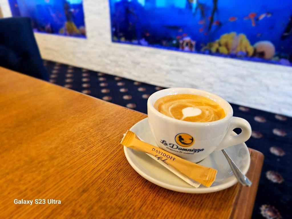 a cup of coffee sitting on a wooden table at Străjerii Cetății in Târgu Neamț