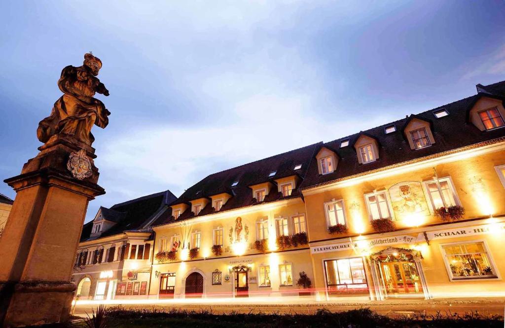 un grand bâtiment avec une statue en face dans l'établissement Hotel Schilcherlandhof, à Stainz