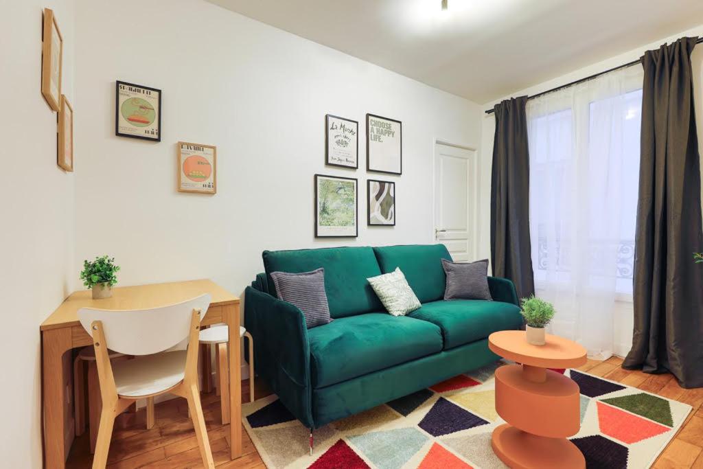 un salon avec un canapé vert et une table dans l'établissement Élégant appartement 1 chambre pour 4 personnes au cœur de Paris, à Bastille, à Paris