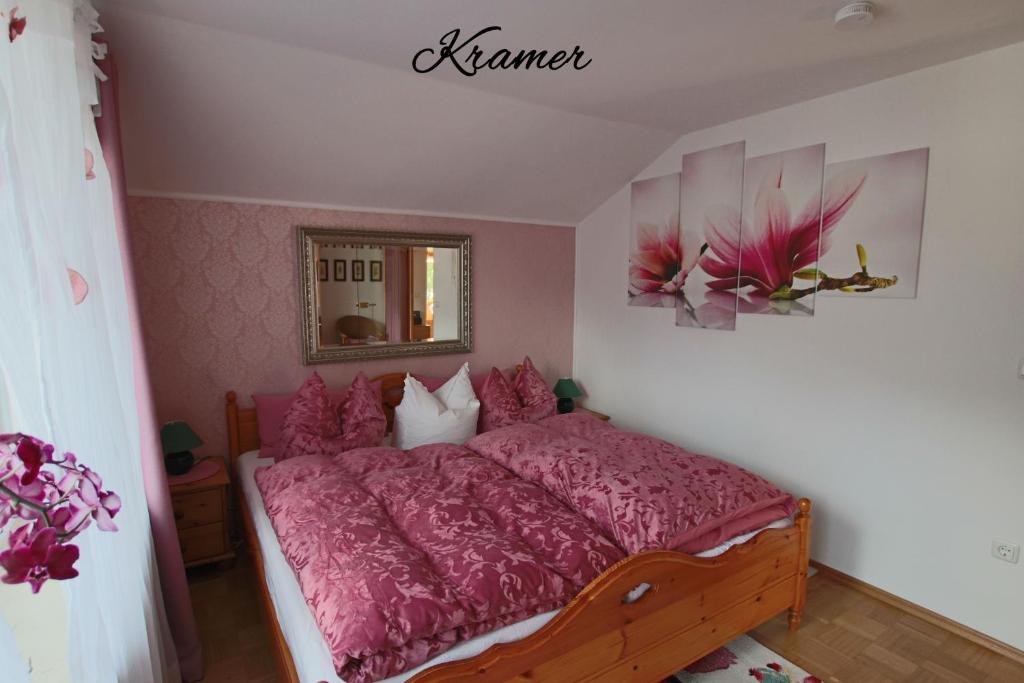 una camera da letto con un letto con lenzuola rosa e uno specchio di Apartment Kramer und Alpspitz a Garmisch-Partenkirchen