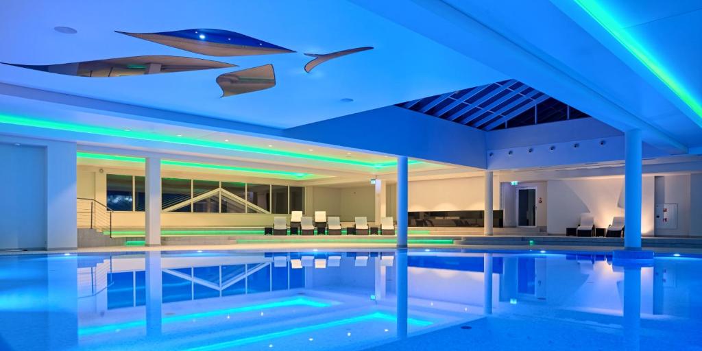 a swimming pool with blue lights on the ceiling at Grand Lubicz Uzdrowisko Ustka in Ustka