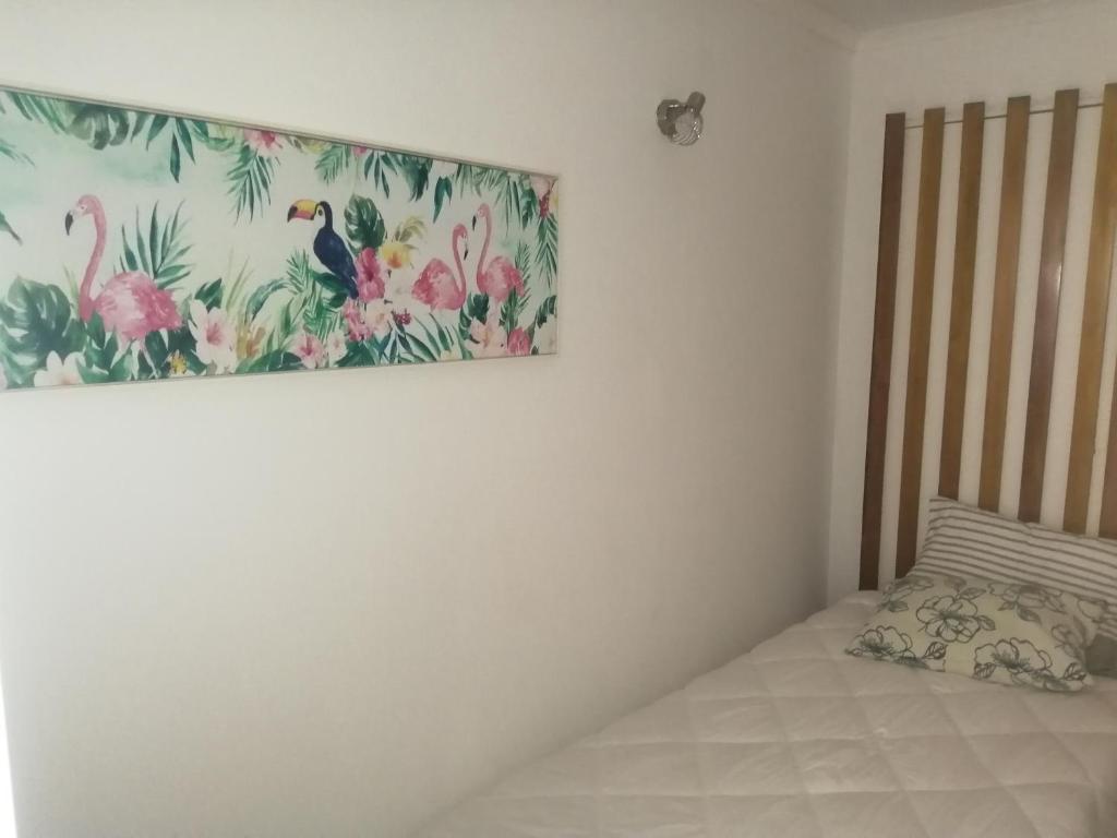 um quarto com uma cama e um quadro na parede em Apartamento T1 Retiro dos Sonhos em Fontes da Matosa