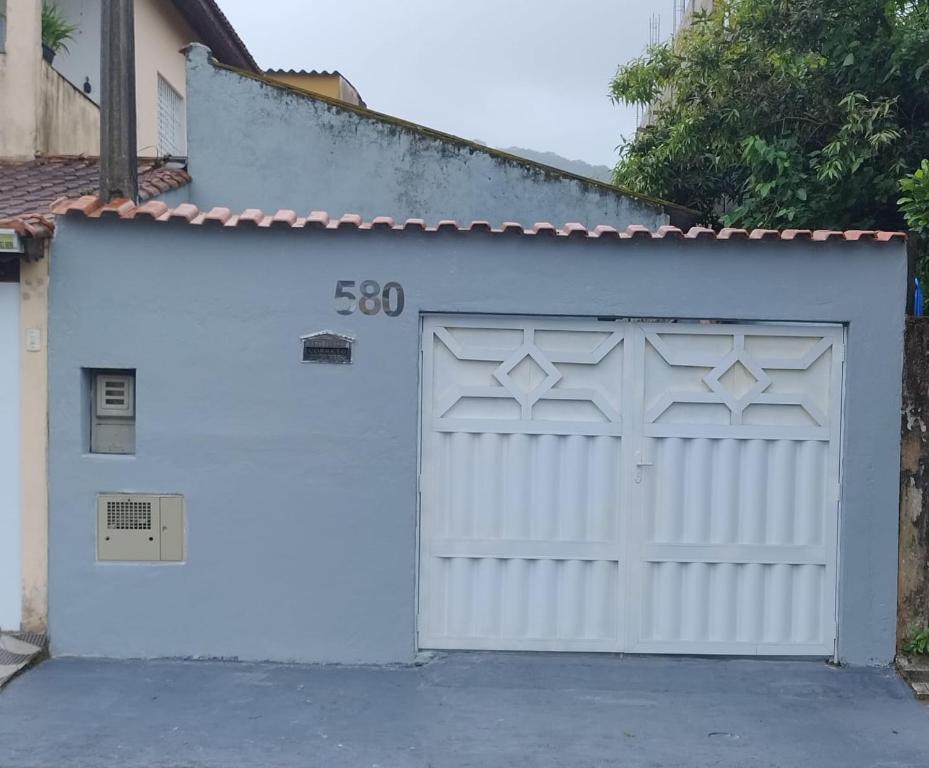 une porte de garage blanche avec son numéro dans l'établissement CANTINHO DA PRAIA, à Mongaguá