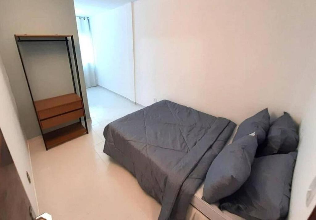 ein Wohnzimmer mit einer Couch und einem Spiegel in der Unterkunft Apartamento aconchegante no centro de São Lourenço 700m do Parque das Águas in São Lourenço