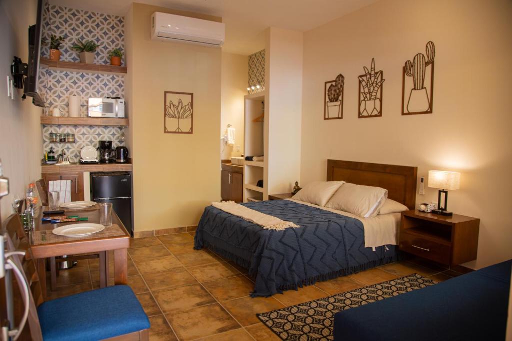 a bedroom with a bed and a desk and a kitchen at Estancia 102 in La Paz